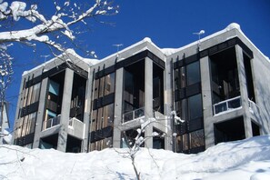 Een modern gebouw met grote ramen en een besneeuwd landschap.