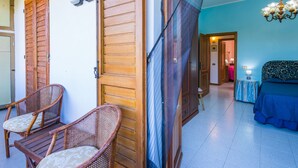 A room with a bed, a chair, a wooden door, and a ceiling fan. - La Casa del Ponte Romano by Interhome (Bucine)