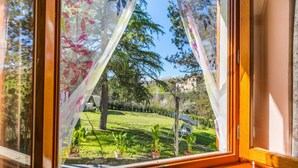 A window with a view of a garden, a chair, and a building in the background. - La Casa del Ponte Romano by Interhome (Bucine)