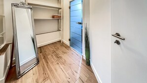 A hallway with wooden flooring, white walls, and a blue door. - Ferienwohnung Blankenhagen (Blankenhagen)