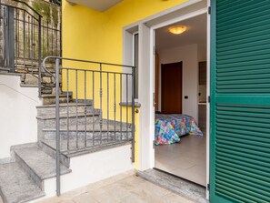Staircase leads to a cozy room with a bed and a green door.