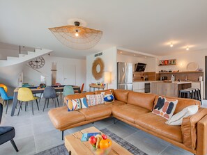 Relax in this spacious living area with a large L-shaped sofa, pool table, and kitchen amenities.