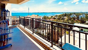 Ein Balkon mit Blick auf das Meer und die Gebäude.