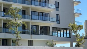Ein mehrstöckiges Gebäude mit Balkonen, großen Fenstern und einem modernen architektonischen Design.