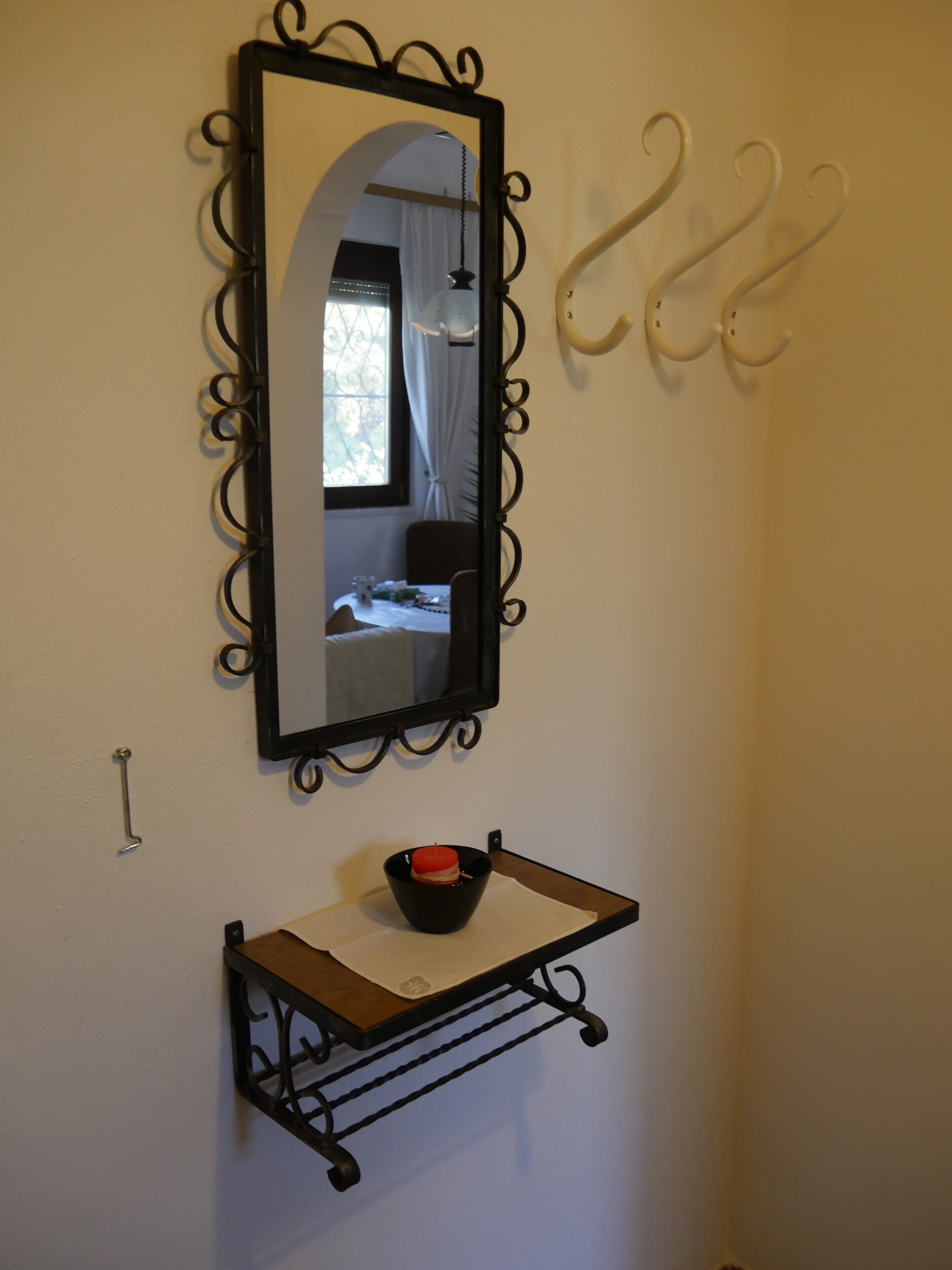 Une salle de bain avec un miroir, un lavabo avec un porte-savon et un porte-serviettes.