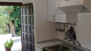 Una cocina con estufa, lavamanos y armarios.
