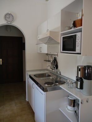 Cocina equipada con microondas, cafetera y lavaplatos doble.