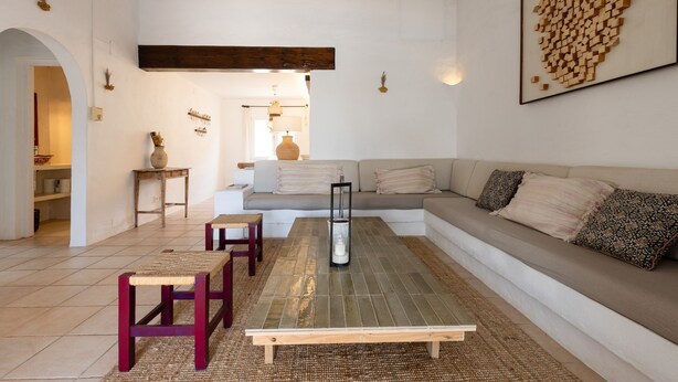 A spacious living room with a large sectional sofa, a coffee table, and a fireplace. - BINISAGOC B - Charming chalet near the sea with free WiFi (Sant Lluís)