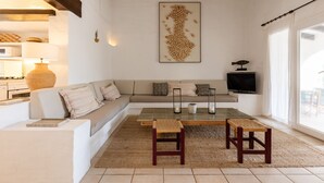 A modern living room with a sofa, coffee table, and a large abstract artwork on the wall. - BINISAGOC B - Charming chalet near the sea with free WiFi (Sant Lluís)