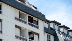 Un immeuble à plusieurs étages, doté de balcons, de fenêtres et d’un toit en pente.