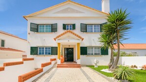 A two-story house with a central entrance, green shutters, and a tiled roof. - Villa 'Kethellen' with Sea View, Private Terrace and Wi-Fi (Porto Covo)