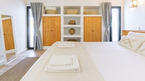 Une chambre à coucher avec un grand lit, des armoires en bois et une fenêtre avec des rideaux.