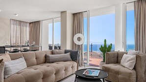 Un salon moderne avec un canapé, une table basse et une vue sur la mer.