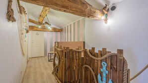 A wooden ceiling with exposed beams, a rope fence, and a wall with vertical stripes. - Holiday Home 'Maison À Cozes' with Private Terrace, Private Garden and Wi-Fi (cozes)