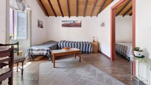 A room with a bed, a table with fruit, a chair, a rug, and a hanging light fixture. - Vacation Home 'Mi Idilio' with Mountain View and Wi-Fi (Teror)