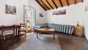 A cozy room with a wooden ceiling, a dining table with chairs, a sofa, a small table with a fruit bowl, and a wooden cabinet. - Vacation Home 'Mi Idilio' with Mountain View and Wi-Fi (Teror)