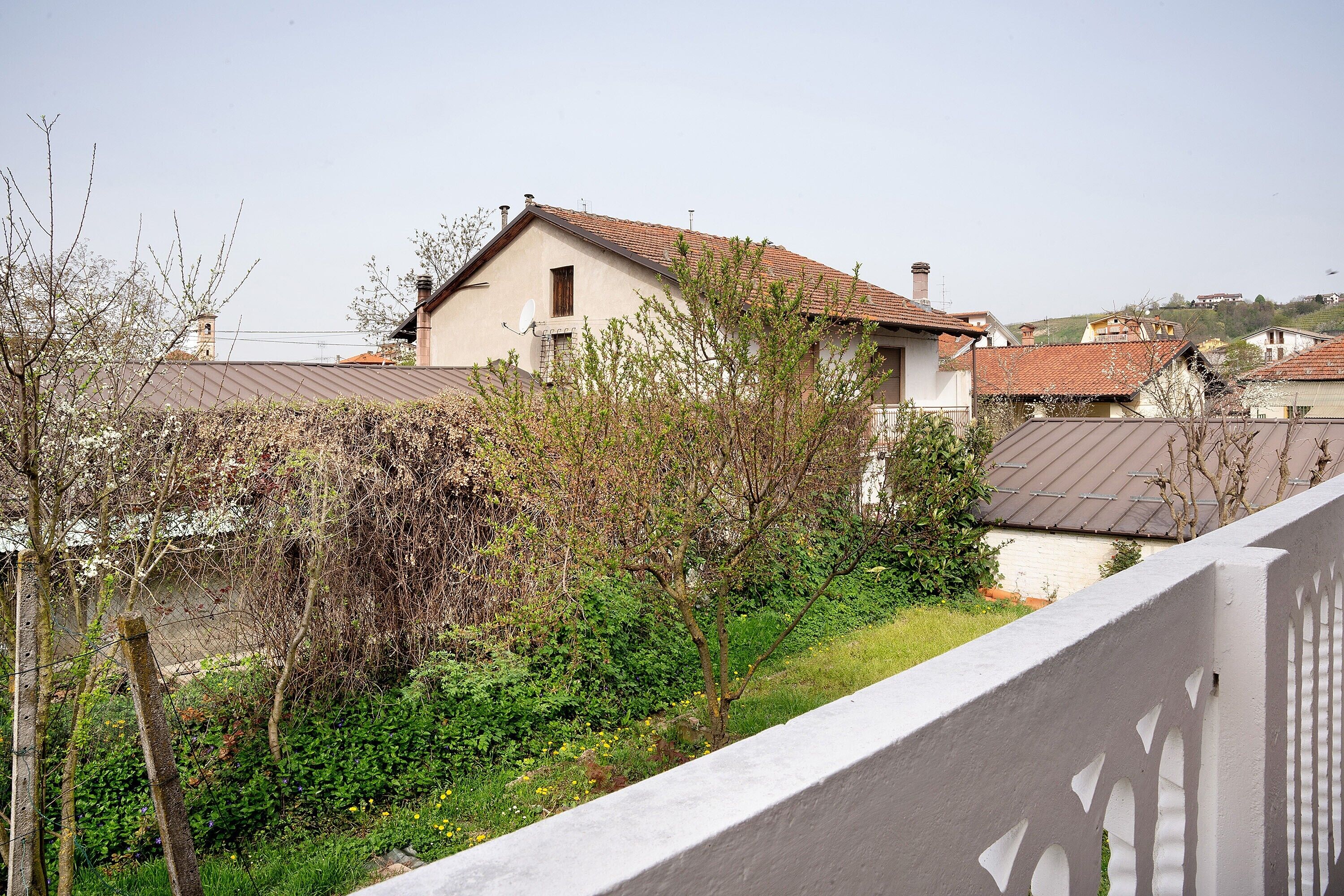 A residential area with houses, a garden, and a white fence.