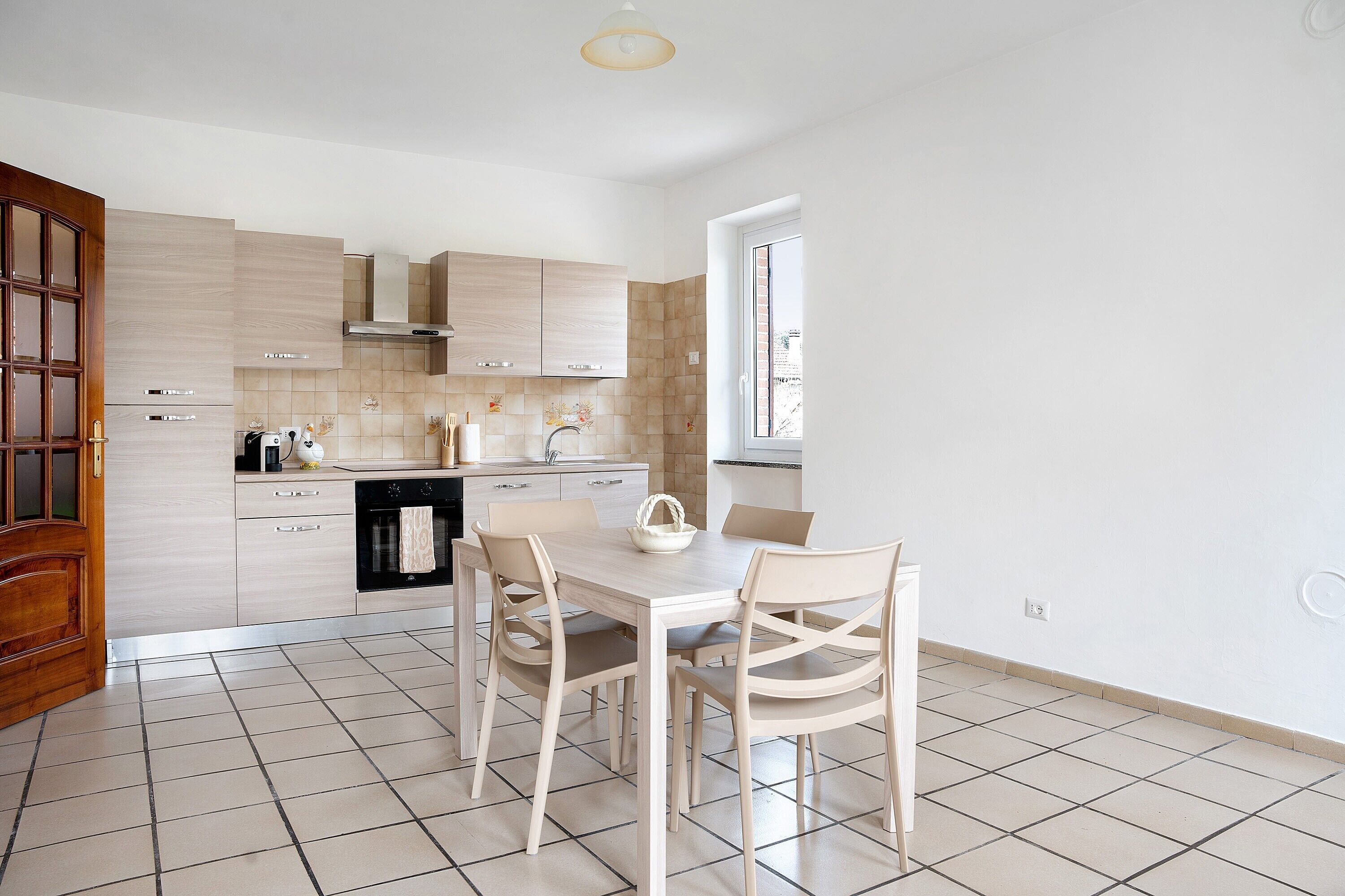 Une cuisine moderne avec une table à manger, des chaises et une fenêtre.