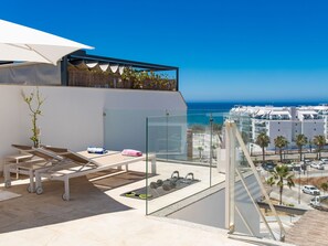 A modern outdoor balcony with sun loungers, a small table, and exercise equipment. - Marinsa Beach Torrox Costa next to Nerja by Interhome (Torrox Costa)
