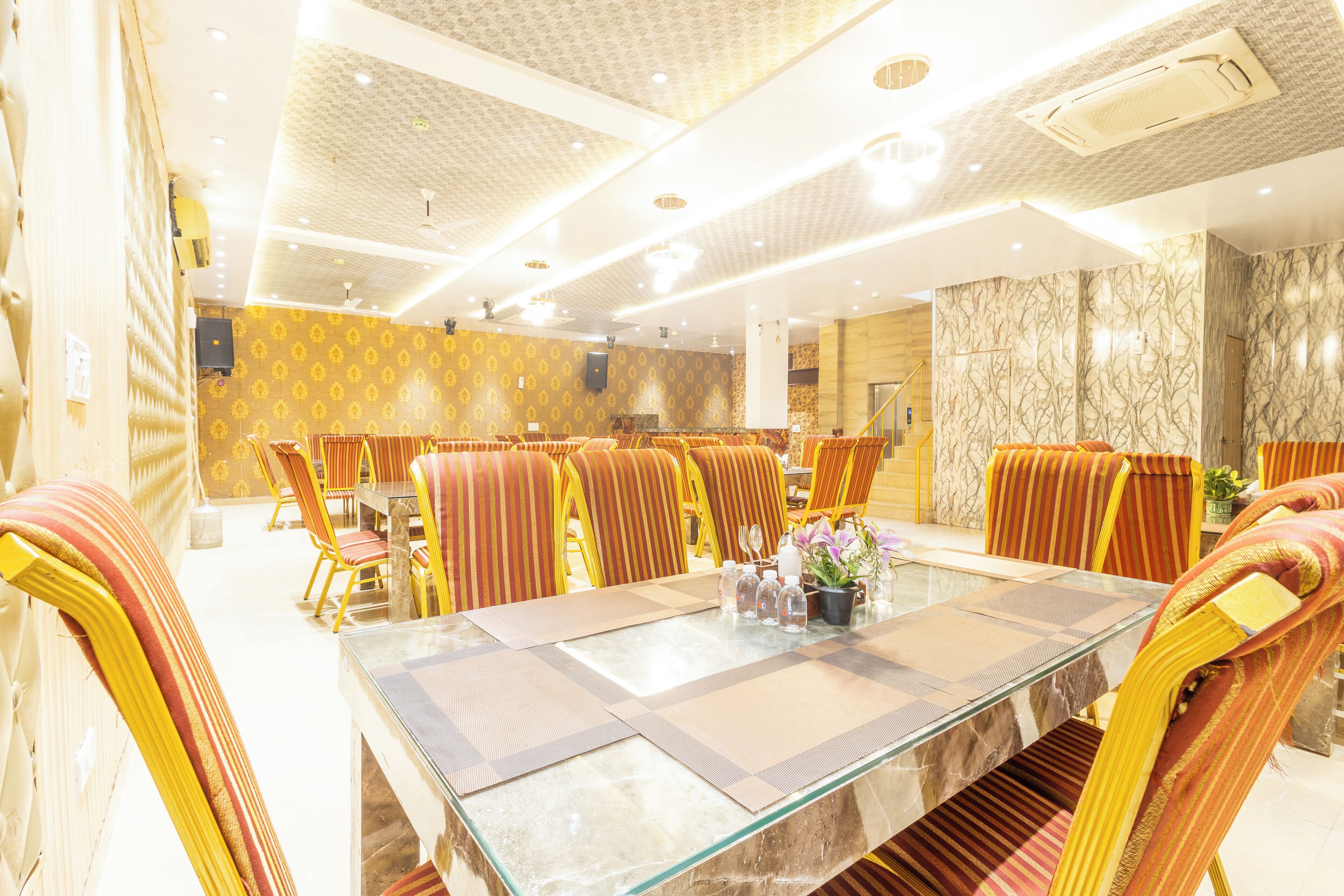 A conference room with a glass table, striped chairs, and patterned walls.