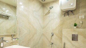 Un baño con lavamanos, inodoro, ducha y espejo.