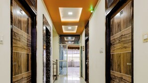 A hallway with marble flooring, wooden doors, and recessed lighting. - The Tiger Heritage  (Sawai Madhopur)