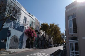 A street with buildings, a parking sign, and a clear sky.