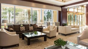 A spacious lobby with large windows, a sofa set, and a coffee table.