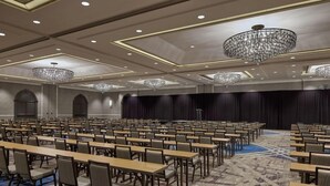 A conference room with rows of tables and chairs, chandeliers, and a patterned carpet. - 2 Connecting Suites at a 4⭐️ Hotel (Arlington)