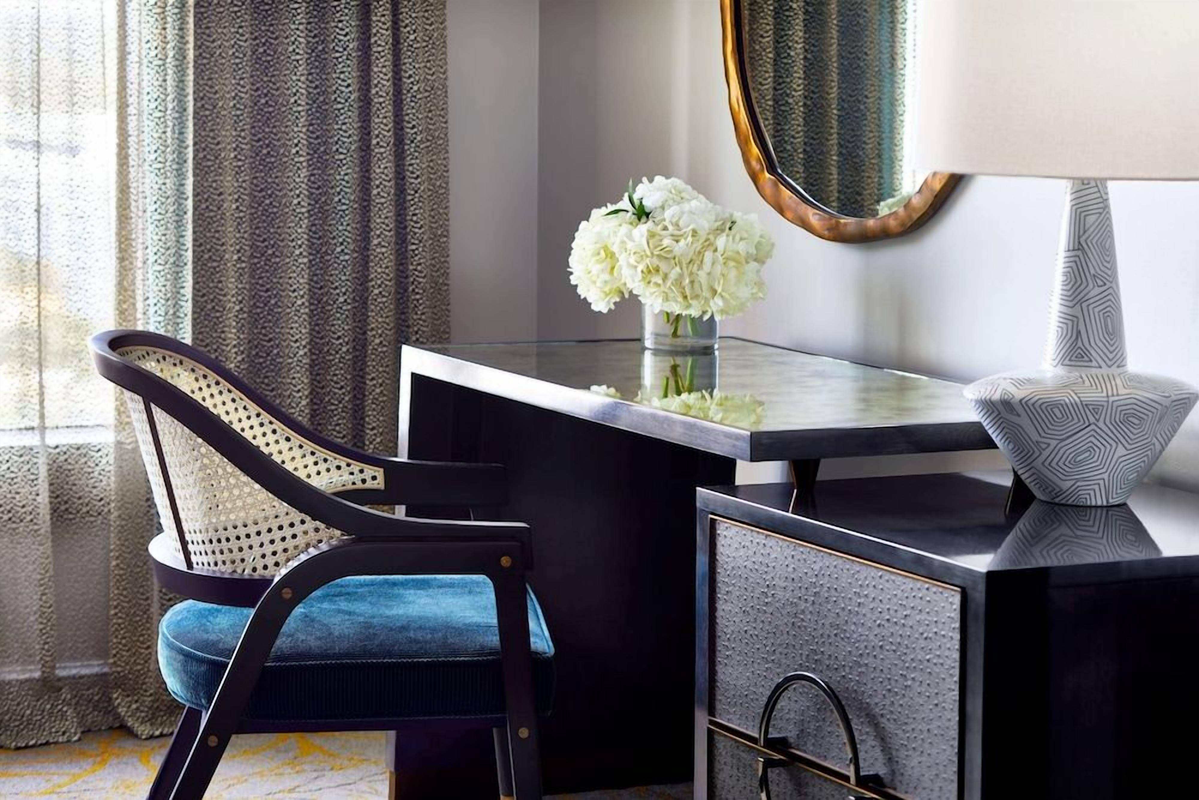 A modern room with a desk, chair, and a mirror.