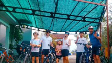 Un grupo de personas bajo un toldo verde, con bicicletas.