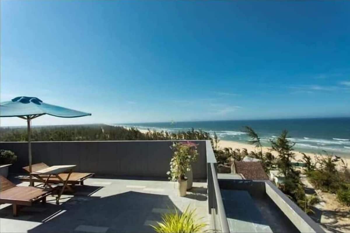Una terraza en la azotea con vistas a la playa y al océano.