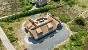 Eine Vogelperspektive eines Hauses mit einem einzigartigen architektonischen Design, das einen Innenhof, einen Swimmingpool und einen gepflegten Garten zeigt.
