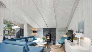 Ein modernes Wohnzimmer mit einem blauen Sofa, einem kleinen runden Tisch und einem Kamin.