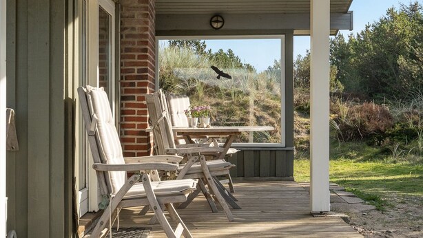 A covered outdoor area with wooden deck, lounge chairs, and a picnic table. - "Neja" - 400m from the sea by Interhome (Blåvand)