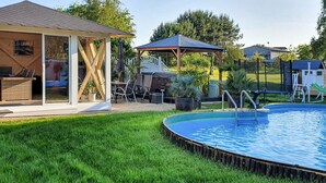 A backyard with a swimming pool, a covered patio, and a gazebo. - Ferienwohnung Neppermin/Usedom (Neppermin/Usedom)