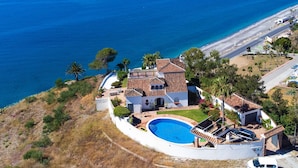 Une propriété située sur la côte, dotée d’une piscine, d’un court de tennis et offrant une vue sur la mer.
