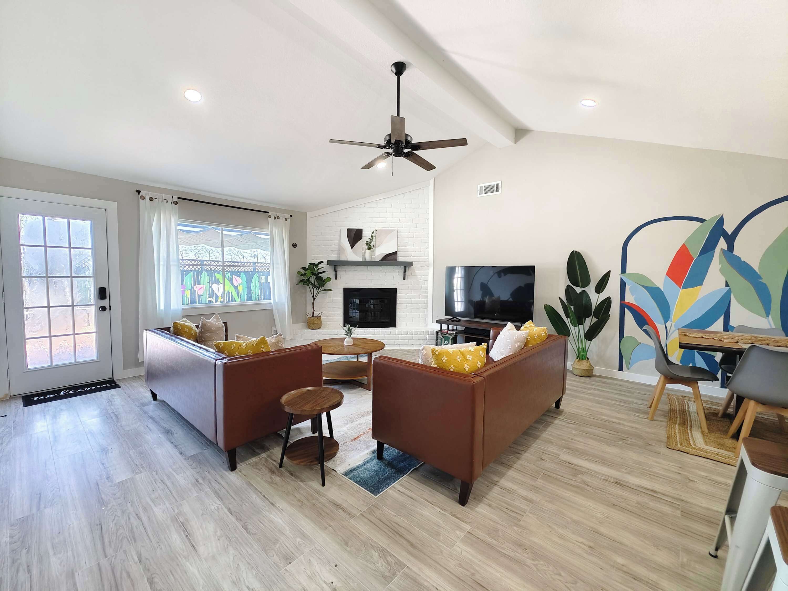 A modern living room with a fireplace, a television, and a dining area with a table and chairs.
