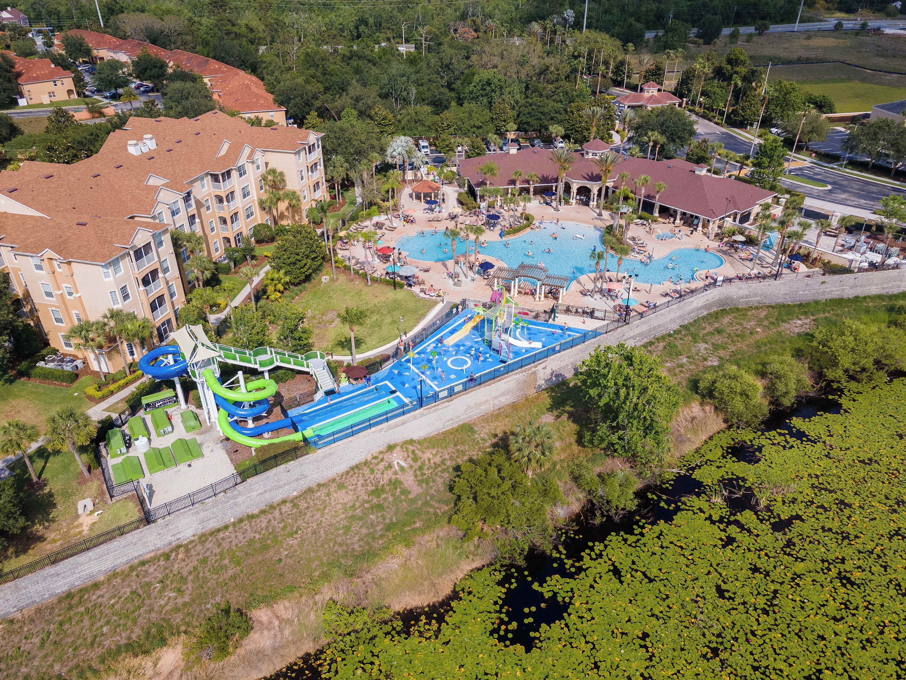 A resort with multiple swimming pools, a water park, and a large building with balconies.