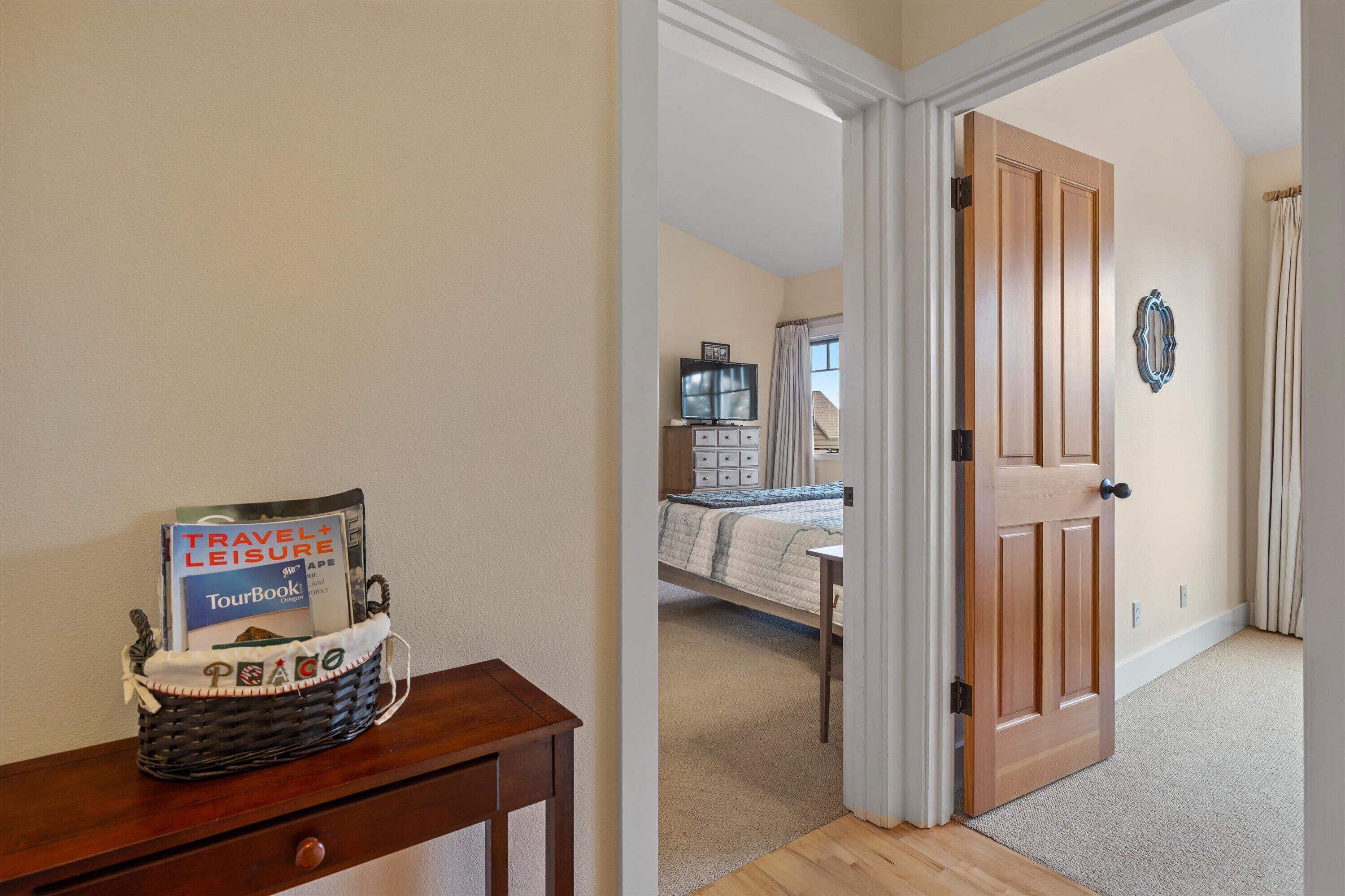 A bedroom with a bed, a TV, and a wooden door.