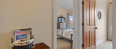 A bedroom with a bed, a TV, and a wooden door.