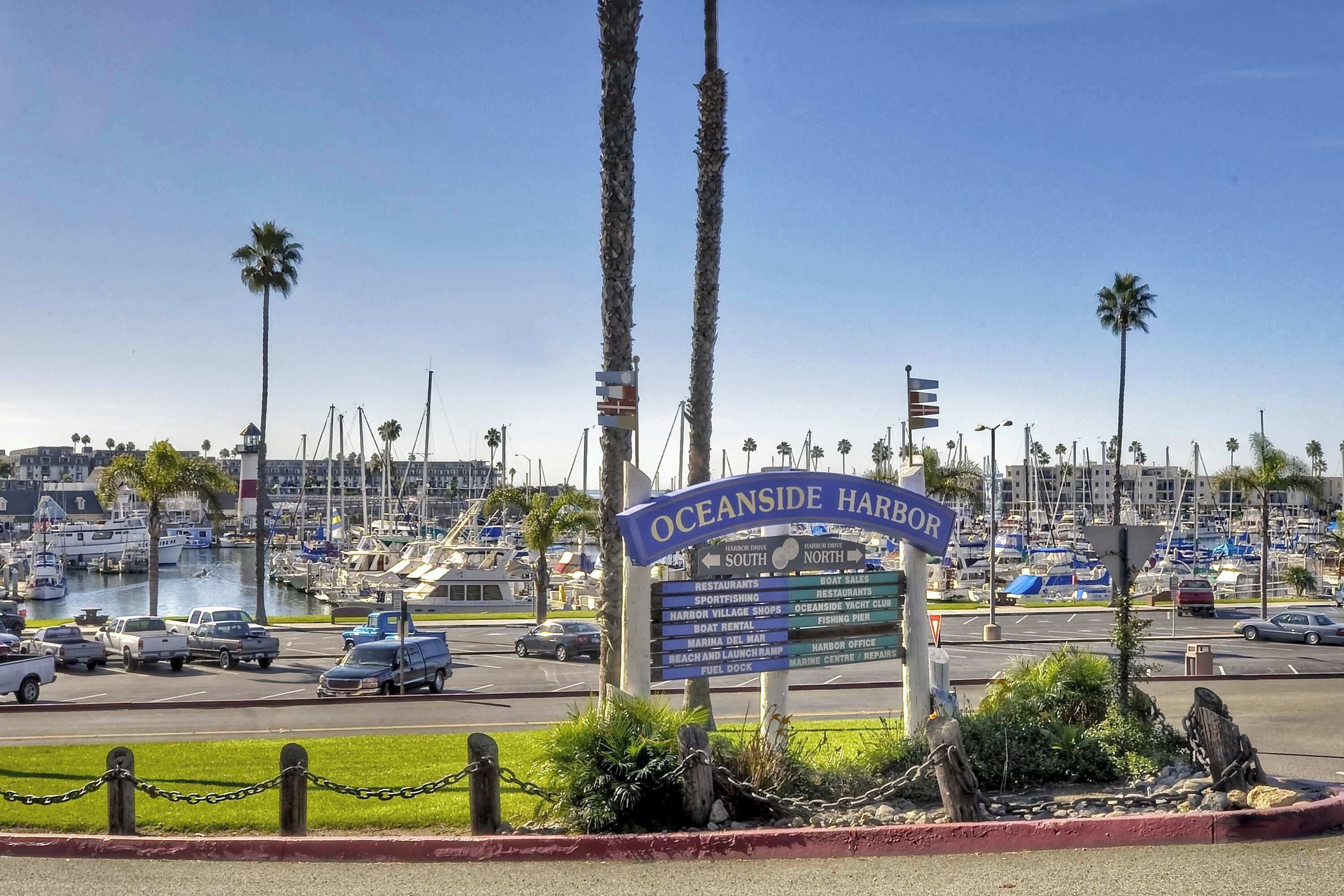A sign for Oceanside Harbor with directions to various amenities like restaurants, marina, and beach.