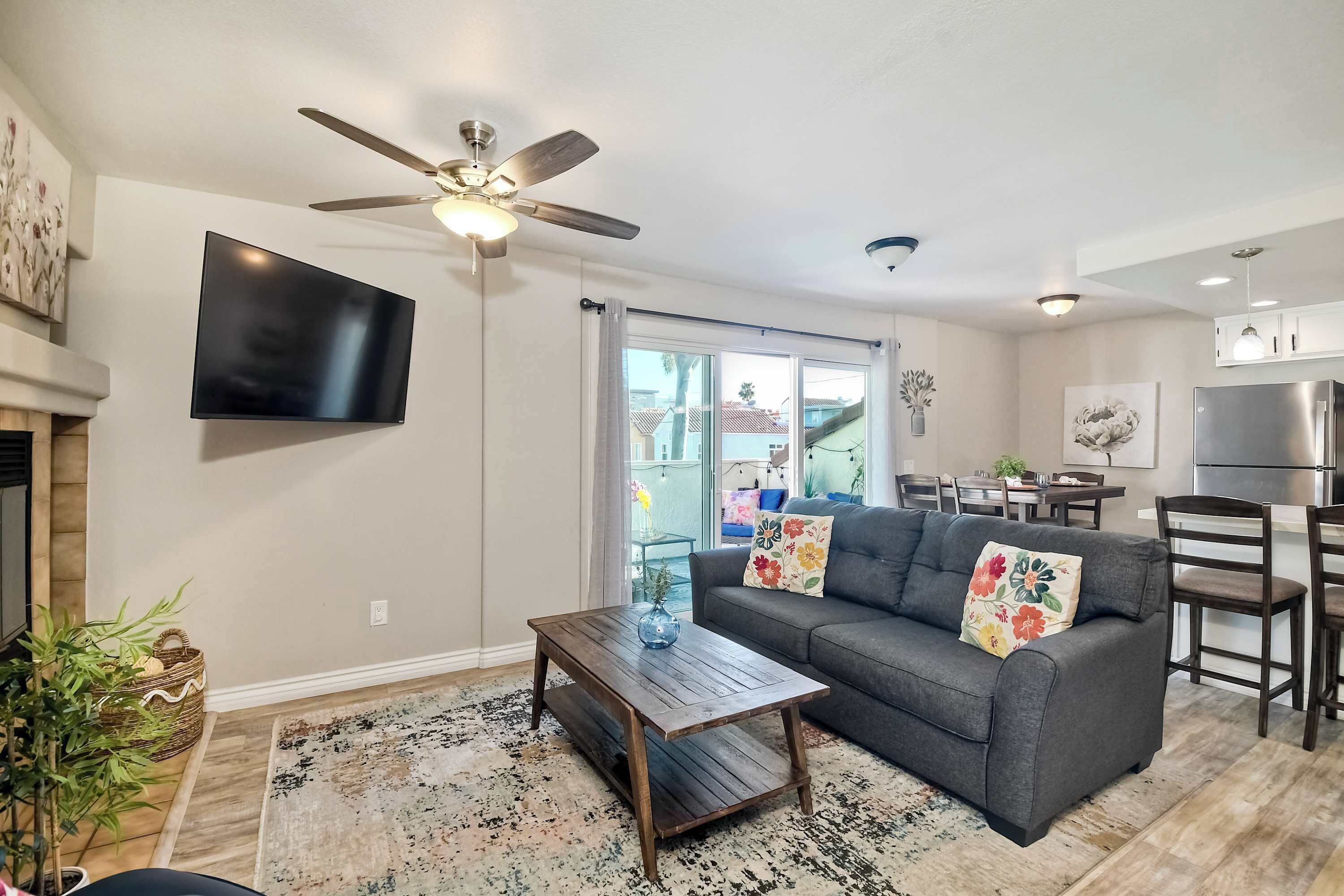 A modern living room with a gray sofa, wooden coffee table, and a ceiling fan.