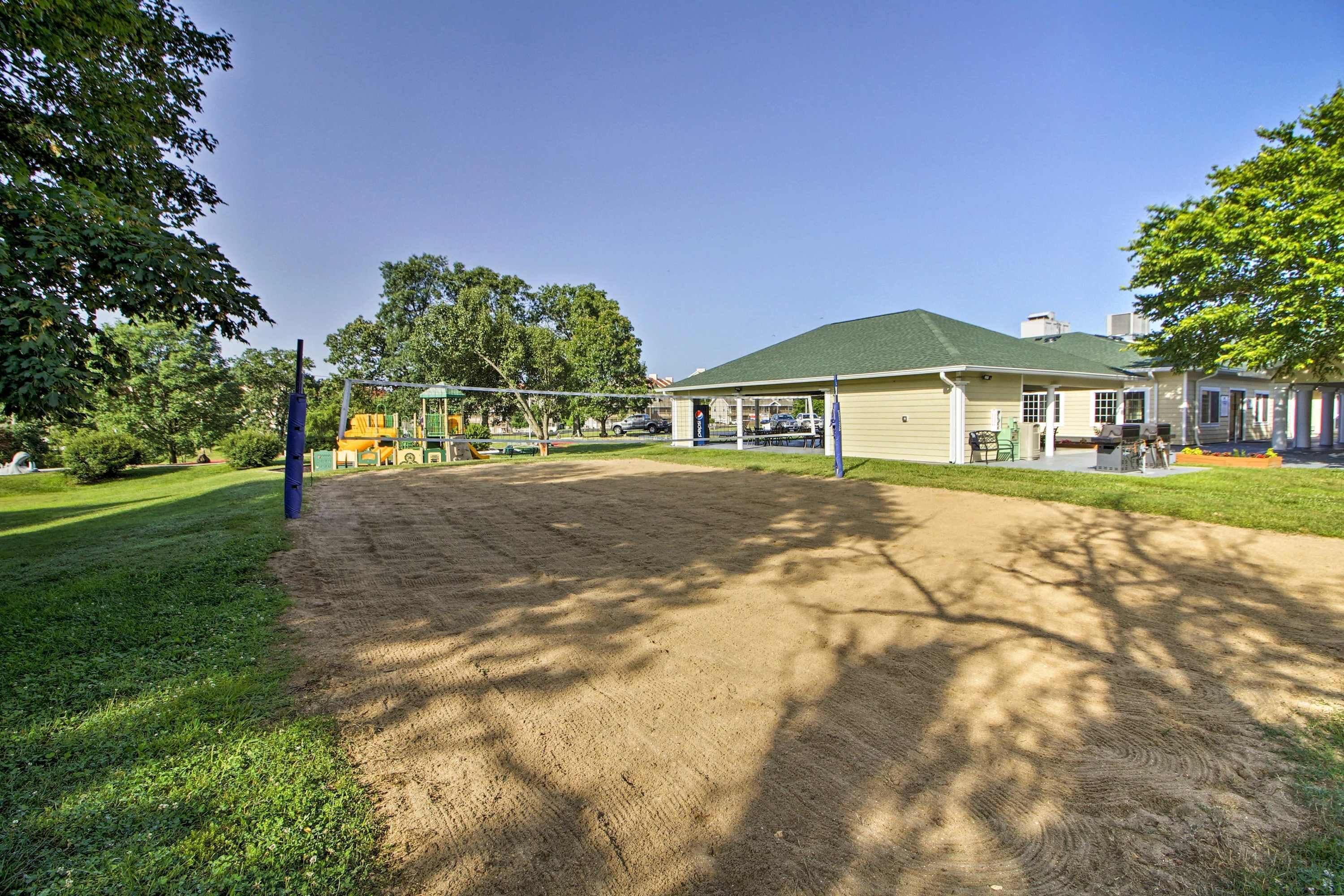 Un terrain de volleyball de plage, avec un bâtiment doté d’un toit végétalisé en arrière-plan.
