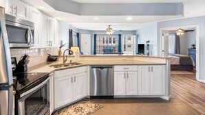 A modern kitchen with white cabinets, stainless steel appliances, and a central island. - Brookside Haven - Gorgeous, Private Community! (Branson)