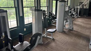 A gym with various exercise machines, large windows, and a carpeted floor. - Birdie's Bliss 2BR Condo Sleeps 6! (Lake Ozark)
