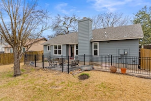 A residential house with a fenced backyard, a chimney, and a small porch area. - Family Friendly Home in South Austin (Austin)