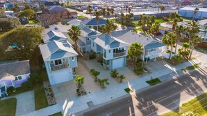 Zona residencial con casas unifamiliares, cada una con garaje y un jardín delantero con palmeras.