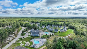 A residential area with multiple houses, a swimming pool, and a road. - Maritime Meadows Charming Resort-style Home! (Kennebunkport)