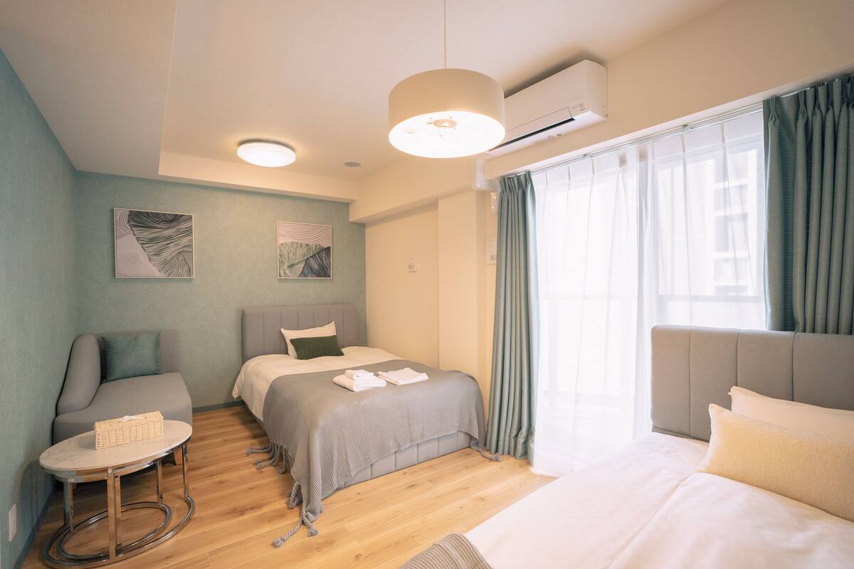 A modern hotel room with a bed, a seating area, and a small table.